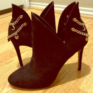 Black booties with gold chains and charms